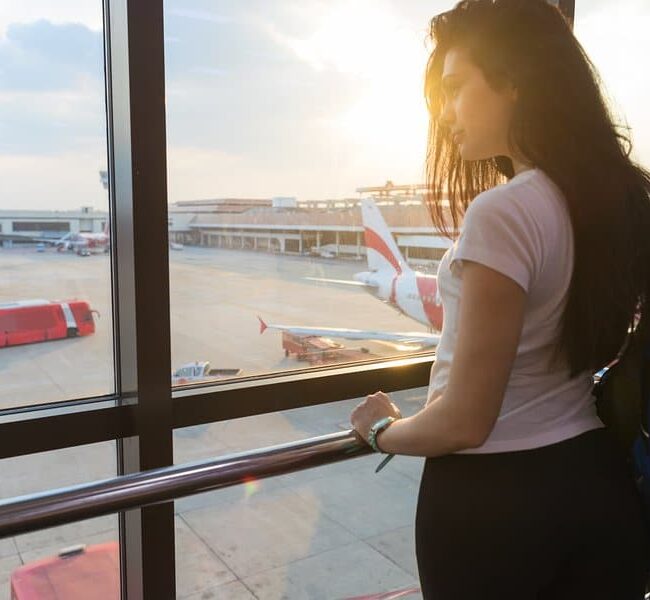 Image of a woman standing by a window in an airport on Aeroseal's website