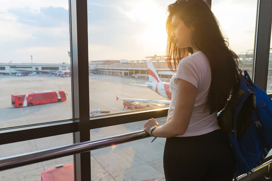 Image of a woman standing by a window in an airport on Aeroseal's website